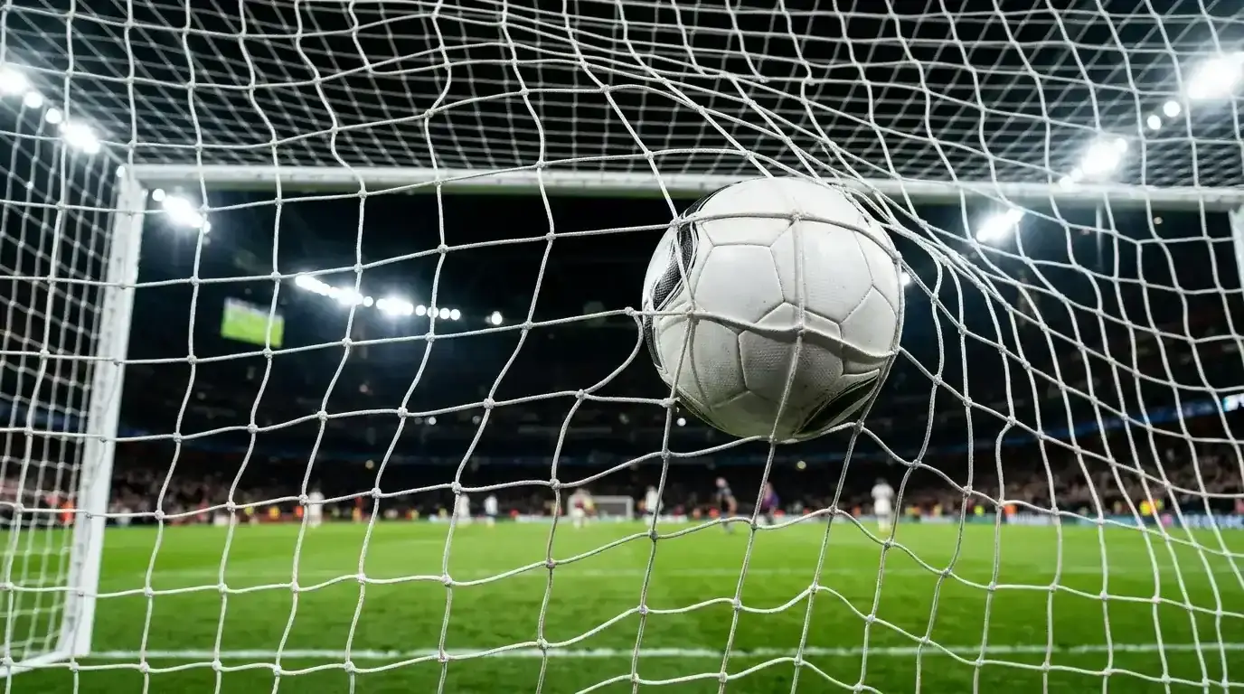 Nogometna žoga v mreži gola z bližnjim posnetkom mrežne strukture